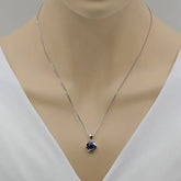 Silver necklace with a blue pendant on a mannequin neck against a white background